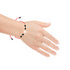A hand adorned with the Big Zirconia Red String Lucky Bracelet and Black Beads Rope, showcasing a heart-shaped charm that sparkles with Cubic Zirconia, set against a pristine white background.